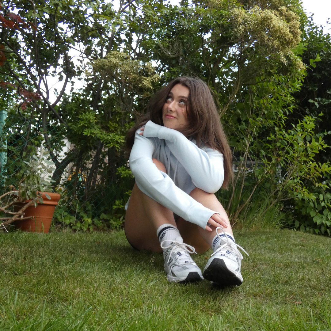 Woman sitting on grass with a blurred background