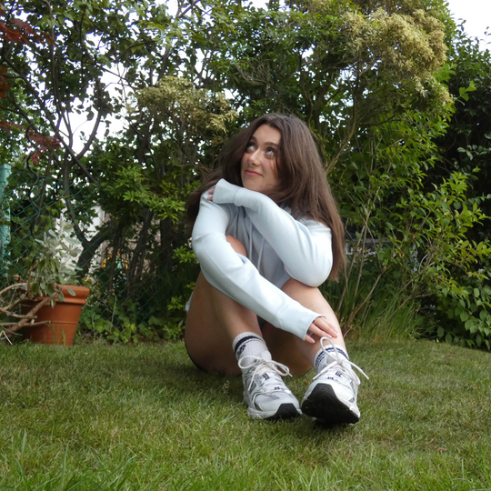 Woman sitting on grass with a blurred background